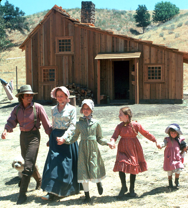The cast in a publicity photo in front of the cabin